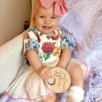 Alicia Banit Instagram - Our Isla Joy is 8 months old! She has a new cheeky smile where she squints her eyes and smiles with her whole face, she has 8 TEETH! with 5 popping through at the same time and surprise surprise she handled it like an absolute champ! She smiles at other people at the shops before they smile at her, she loooves looking at pictures of herself and she’s currently obsessed with waving 🥹 When she cries now she has tears which breaks our hearts but at the same time my god it’s CUTE! and she absolutely adores animals and other children. We still get told every single time we go out that we just have the happiest and chillest lil babe and honestly, I concur. Her personality is growing and evolving every day and we’ve loved nothing more than watching every second of it. My gosh we are the luckiest parents, I do not wish this time away at alllll but I also can’t wait to see who she becomes 🥹🤍