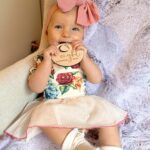 Alicia Banit Instagram - Our Isla Joy is 8 months old! She has a new cheeky smile where she squints her eyes and smiles with her whole face, she has 8 TEETH! with 5 popping through at the same time and surprise surprise she handled it like an absolute champ! She smiles at other people at the shops before they smile at her, she loooves looking at pictures of herself and she’s currently obsessed with waving 🥹 When she cries now she has tears which breaks our hearts but at the same time my god it’s CUTE! and she absolutely adores animals and other children. We still get told every single time we go out that we just have the happiest and chillest lil babe and honestly, I concur. Her personality is growing and evolving every day and we’ve loved nothing more than watching every second of it. My gosh we are the luckiest parents, I do not wish this time away at alllll but I also can’t wait to see who she becomes 🥹🤍
