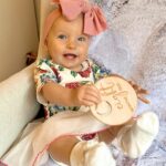 Alicia Banit Instagram - Our Isla Joy is 8 months old! She has a new cheeky smile where she squints her eyes and smiles with her whole face, she has 8 TEETH! with 5 popping through at the same time and surprise surprise she handled it like an absolute champ! She smiles at other people at the shops before they smile at her, she loooves looking at pictures of herself and she’s currently obsessed with waving 🥹 When she cries now she has tears which breaks our hearts but at the same time my god it’s CUTE! and she absolutely adores animals and other children. We still get told every single time we go out that we just have the happiest and chillest lil babe and honestly, I concur. Her personality is growing and evolving every day and we’ve loved nothing more than watching every second of it. My gosh we are the luckiest parents, I do not wish this time away at alllll but I also can’t wait to see who she becomes 🥹🤍