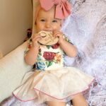 Alicia Banit Instagram - Our Isla Joy is 8 months old! She has a new cheeky smile where she squints her eyes and smiles with her whole face, she has 8 TEETH! with 5 popping through at the same time and surprise surprise she handled it like an absolute champ! She smiles at other people at the shops before they smile at her, she loooves looking at pictures of herself and she’s currently obsessed with waving 🥹 When she cries now she has tears which breaks our hearts but at the same time my god it’s CUTE! and she absolutely adores animals and other children. We still get told every single time we go out that we just have the happiest and chillest lil babe and honestly, I concur. Her personality is growing and evolving every day and we’ve loved nothing more than watching every second of it. My gosh we are the luckiest parents, I do not wish this time away at alllll but I also can’t wait to see who she becomes 🥹🤍