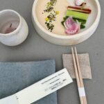 Ally Maki Instagram – Cherry blossom tea ceremony by Tomoko Imade Dyen @turningoffjapanese x @owiugoods. This was hands down one of the most special experiences I’ve had lately. Tomoko, who is an experienced Culinary Curator from Japan, just got back from Kagoshima (which is where my family is from) to curate and bring back some of the most special teas of the many seasons of Japan.
Tea ceremonies are more than just the act of drinking tea, but an invitation to commune and appreciate ritual and stillness. We learned so much about different teas and their origins, discovered my new favorite tea Chirancha, tried fermented Awabancha with sweet natto and Genmaicha from the shop in Kyoto where it was originally created. Each tea is paired with a handmade wagashi by @adzuki_life all served on @amandagnwn OWIU pottery. The whole ceremony was exceptional and brought us right back to Japan. Sign up for one of her future events (she has a waiting list!) We are bringing this experience to @asianamericangirlclub very soon so stay tuned. Trust me you will not want to miss this when it happens.
Our menu:
Sparkling Fukamushi-cha (Shizuoka)
Spring Crudités
Chirancha (Kagoshima)
Asparagus spring roll
Fermented tea tasting (Awabancha-Tokushima, Oolong-Kagoshima; Kohcha- Kyoto)
Savory and sweet Natto
Genmaicha (Kyoto)
Seasonal oshokuji
Matcha (Kyoto)
Sakuramochi and Sakura Mochi and Sakura Kiribashi by KASHI AMAIRO