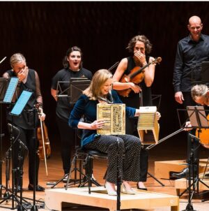Annabel Crabb Instagram - This is the moment on Tuesday night at which Scottish-born classical accordionist James Crabb viciously pranked @leigh_sales by handing her a BOOBYTRAPPED squeezebox on stage at the Opera House in front of the @australianchamberorchestra. Image captured by @mr_stephenblake who will be punished separately as he was forewarned of the gag. Now I know what they say:
“Never a fistfight picking be
With a man who was birthed in Dundee”
But I say to you, squeezebox man. This Adelaide Plains bogan has one more show with you, TONIGHT at Hamer Hall @artscentremelbourne. And at some point in that ninety minutes, I will END you.
Capiche? @chat10looks3 
Tickets still available. Bring swabs.