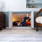 Ashley Williams Instagram – “My name’s Gus and I like small spaces,” my nine year old used to introduce himself to people this way. He loves reading, drawing, and “being cozy,” so when we considered designing a bedroom for him, the only answer was this mahogany treehouse vibe. We went to @roomandboard and had the best time designing exactly to his sensibility. He loves to sit at his desk and “imagine that I’m in the forest.” I’m obsessed with Room and Board’s sturdy, clean lined aesthetic and sometimes on stressful days I go hide in there myself. 😆 #homerenovation #kidsroom @we_are_kismet @alchemy_collective_ #roomreveal #ad