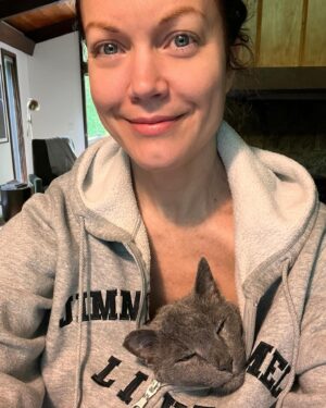 Bellamy Young Instagram - This made me smile, so I thought maybe it would you too...🥰 Made a cup of coffee & sat down to journal for a minute this morning. Razor was beside me as always, but my old man cat Button decided he wanted to be a part of the proceedings. He's gotten all sentimental in his old age & now does the sweetest things out of the blue. He jumped up in my lap, snuggled under my sweatshirt, popped his head out the top, & promptly fell asleep, his little purrs softly vibrating through me. 🥰 
Hope you get some surprise love today too! I'm wishing you all the best! 🥰☕️📖😻❤️