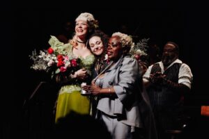 Betty Who Instagram - some moments from my last day at the Walter Kerr 😭🚂🍷
i am endlessly grateful i got to ride that train to the end of the line with my new and now forever family @hadestown 
i think it’s gonna take me a while to stop constantly running steps and songs in my head getting ready for that nights performance.
thank you to every single one of you who have supported me on this journey! it’s so vulny! to just… do something you have literally never done before and just hope you don’t embarrass yourself! so many of you have been sooo kind and reassuring. the way i have been gassed up at stage door by some of yall?!?!? and god bless my FRIENDS. you beautiful people. who have been so patient and gentle with me while this schedule has taken over my life.  i know shows are expensive and not everyone is a musical theatre nerd like me! the fact that so many of you travelled from far and wide to buy a ticket to Hell just to show up for me blows my mind. i love you all so much. 
sharing a closing night with @_solaylay will be a core memory for ever and ever. it’s rare at this age to connect with someone and feel like you’ve been friends since birth. that’s me and this silly goose! see u soon bean u’ll never be rid of me now!
finally just a lil note about @zcassar 
this man. this MAN!!! zak has been the most supportive partner to me in the last six months in a way i can’t really put words to. this lifestyle is hard, especially being away from home for as long as we have been. to imagine doing it without him seems impossible. not to mention sitting yesterday with him, going through the images he has captured of this part of my life. the way he sees the world is such beautiful art. he always says his best pictures are the ones he takes of people he loves. that’s why his best pictures are always of me 🥹😭😭😭 
this has been such a huge chapter. i have learned so much and am SO. GRATEFUL! if there’s one thing about me, it’s that i’m just a show girl at heart! 
HERE’S TO MORE SHOWS! MORE WIGS! MORE ADVENTURES IN THE THEATRE TO COME! ⭐️