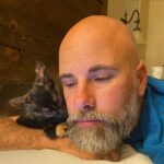 Briana Renee Instagram - Quinn (aka Mimi’s) is all about @manning_party_of_5 💜👉🏻 #catdad #purrfect #adoptdontshop #wrappedaroundherpaw 🐾 #catsofinstagram 🖤🧡 #bestillmyheart #sweetdreams