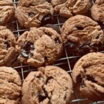 Briony May Williams Instagram - Now these cookies are something else!!! Peanut Butter, Chocolate and Fennel…yes fennel! I came up with the combo when prepping for the Bake Off recipes and trust me when I say they are next level delicious 🤤 I made over 100 of these for people to taste this weekend at the @royalbathandwest Food and Drink Festival and they went down an absolute treat!!! You can swap out the peanut butter for biscoff spread (or do half and half!) and leave the fennel out if you want (but they taste amazing with it!). Enjoy!!! ❤️ Peanut Butter, Chocolate Chip and Fennel Cookies Ingredients 125g unsalted butter, softened 250g chunky peanut butter/biscoff spread 125g golden caster sugar 175g light soft brown sugar 1 large egg 300g self raising flour 1 tsp salt 1-2 tsp crushed fennel seeds 250g dark chocolate chips Method 1. Oven on to 180°C. Line 2 baking trays with parchment. 2. Butter, peanut butter and sugars in stand mixer with paddle attachment. Beat until well combined. 3. Egg and milk in a mug and beat with a fork until combined. Tip into butter mixture and beat till combined. 4. Flour, bicarb, baking powder, salt and crushed fennel seeds in a bowl. Whisk to combine. 5. Tip flour mixture into butter mixture and gently mix until combined. Add choc chips and mix until just combined. 6. Break off a brussel sprout size piece of cookie dough and roll into a ball. Place on parchment and press down to flatten. 7. Bake for 8-10 minutes until they are just hardening. Put on cooling rack. The dough will last in the fridge for a week and the freezer for 2 months. #cookies #peanutbutter #peanutbuttercookies #chocchip #chocolate #chocolatechipcookies #fennel #bestcookiesever #recipe #delicious #tasty #baking #baker #homebaking #homebaker