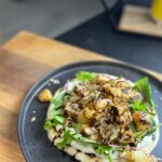 Briony May Williams Instagram - Today’s episode from my seasonal recipes series features the often overlooked, never the belle of the ball…the humble celeriac ❤️ This Spiced Celeriac on a Yogurt Flatbread is so yummy and delights the tastebuds with hints of mixed spice combined with the nuttiness of the celeriac. Trust me, it’s delicious!!! #seasontotaste Spiced Crispy Celeriac on Yogurt Flatbread Serves 2 Ingredients 1 celeriac 1 tbsp olive oil 1 tsp cornflour 1 tsp mixed spice 1 tsp cumin Flatbread 200g self raising flour 200g greek yogurt Yogurt Dressing 2 tbsp greek yogurt 1 tbsp honey/agave syrup ½ tsp mixed spice ½ tsp cumin To serve (optional) Salad leaves Mixed seeds Balsamic glaze Method Peel and chop the celeriac into 3cm chunks. Place in a pan of boiling water and a pinch of salt and cook for 6-7 minutes then drain. While the celeriac is boiling, make the dough. Mix the flour and yogurt together with a generous seasoning of salt and pepper to form a soft dough. Knead for a minute then form into a ball and set aside to rest for 5 minutes. Make the dressing by mixing the ingredients together in a bowl until combined. Make the bread by slicing the dough in half and roll each half out on a floured surface into a circle roughly ¼ inch thick. Heat a frying pan with a drizzle of olive oil, once hot add the dough and cook for 3 minutes then flip and cook the other side for a further 3 minutes. Cook until each side is golden brown and the bread is cooked through. Repeat with the other half of the dough. Place the drained celeriac in a bowl and drizzle over the olive oil. Mix. Combine the cornflour, mixed spice and cumin then sprinkle over the celeriac and mix well to coat. Heat a drizzle of olive oil in a pan, once hot add the coated celeriac and cook for 10-15 minutes until crispy on the outside and tender on the inside. Place flatbread on a serving dish. Spread over half the dressing, top with salad leaves and the crispy celeriac. Drizzle over the balsamic glaze, sprinkle the seeds then enjoy! #seasonal #season #celeriac #recipe #yummy #delicious #easycooking #easymeals #healthy #vegetarian #vegan #plantbased #lunchideas #lunch #bread #flatbread