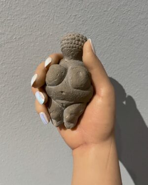Carlota Guerrero Instagram - “Sofia Willendorf”
Silicon, hair and clay (2022) @staatsgaleriestuttgart #carlotaguerrero 

“An apparent visitor stands serenely in a corner of the exhibition room. She has her back turned to the rest of the viewers and looks down towards a small figurine she holds with one of her hands. 

Titled Sofia Willendorf, the installation takes the historian and anthropologist LeRoy McDermott and Catherine Hodge's thesis from their article Decolonizing Gender: Female Vision in the Upper Paleolithic (1996) as the starting point. In the text, the authors criticize the way the first images of human bodies, the Venus figurines, have generally been interpreted “as sex objects made from a male point of view”. Instead, they argue, they were made by women and for women  as a form of self-representation. Following this, the apparent distortions of the anatomy of the figurines become apt renderings if we consider the body as seen by a woman, presumably pregnant, looking down on herself.
 
Regardless of the veracity of the argument —which seems perfectly logical and credible— the question remains; why did it take so long to consider the logical possibility that a female point of view was involved?
 
Sofia Willendorf gives voice to that pregnant woman in the contemporary context, where past and present archetypes are confronted under the veil of an imposed male gaze the artist tries to subvert. A certain discomfort emerges while staring at the duo, ironically separated by 30,000 years gap. Originally purchased as a sex doll manufactured in China, the contemporary visitor cheerlessly exemplifies both the prevalence and the profound influence of the patriarchy."

text and curation
@marionavaldestorrella