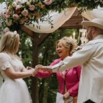 Caroline Rhea Instagram - You’re supposed to put a handful of rose petals in a little wooden box every time you have a “perfectly, lovely day” This was one of them. Getting to officiate the wedding of my beloved friends @forestblakk and his gorgeous wife @tooleyjones. No pressure to think of something to say in front of a poet and his muse. @forestblakk (CANADIAN) has 100 million streams on his songs. Sooo talented. They got married by a beautiful forest so when he walked down the aisle I actually got to say, “I can see the Forrest through the trees!” (What? I’m a comedian!) Tooley couldn’t have looked more beautiful. This might be the best perk I ever got from being #AuntHilda” Soul mates to family❤️ Wish the happy couple Congratulations @tooleyjones @forestblakk #weddingday #junewedding #love