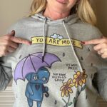 Catherine Sutherland Instagram - “It will pass” one of the most important affirmations we need to remind ourselves. It’s important to know that the storms in our lives are temporary and are meant to help us grow. The struggles we have with Mental Health are real. Your feelings are real. You are more capable than you could ever imagine. Keep fighting. ☔️🌻 Thank you to my friend @catherine_sutherland a superhero on the tv screen and in real life. She’s been a true supporter and believer along with @nakiaburrise on what we’re doing here. 💕 Hoodie designed and illustrated by @melotica.rt grab this design before we retire it this month. Link in bio #mentalhealth #itwillpass #keepfighting #suicideprevention #depression #anxiety #youaremorethanenough #powerrangers #pinkpowerranger