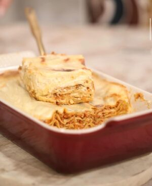 Cátia Goarmon Instagram - No @doisas10tvi com os meus queridos @claudio_ramos e @dailycristina a fazer a maravilhosa lasanha de atum com picadinho de legumes! 💥

Ingredientes:
* 1 cenoura
* ½ couve-flor (só os floretes)
* ½ brócolo (só os floretes)
* 1 cebola picada
* 2 dentes de alho picados
* 1 talo de aipo picado
* 100ml de vinho branco
* 400ml de polpa de tomate
* 3 latas de atum em azeite (escorrido)
* 3 c. sopa de Pão ralado
* 250g de massa fresca para lasanha
* 400ml molho bechamel
* 200g queijo mozarela ralado
* Azeite q.b.
* Flor de sal q.b.
* Mistura de Pimentas q.b.
* Orégãos secos q.b.

Modo de preparação:

Num processador de alimentos, triture a cenoura, os floretes da couve-flor e dos brócolos e o talo de aipo, de forma a obter um granulado. Reserve.
Refogue, em azeite, a cebola e os dentes de alho. Junte os legumes triturados e cozinhe-os até que estejam macios. Acrescente o vinho branco e deixe evaporar o álcool. Deite no tacho o atum, a polpa de tomate, os orégãos e deixe cozinhar, por 20 minutos, em lume brando. Tempere com sal e pimenta a gosto.
Para montar a lasanha, forre o fundo de uma travessa com o pão ralado. De seguida, deite um pouco do preparado de atum, coloque um pouco de queijo e tape com duas folhas de massa fresca. Continue o processo, até acabar o preparado de atum. Termine com as folhas de massa, cubra com o molho bechamel e um pouco de queijo mozarela.
Leve ao forno a 180ºC, por 45 minutos.