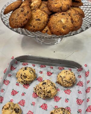 Cátia Goarmon Instagram - E para acabar em bom…. 🥁 Chocolate chip cookies! 🍪 

INGREDIENTES:
 • 100g de manteiga à temperatura ambiente
• 100g de açúcar amarelo
• 1 ovo
• 150g de farinha
• 50g de amido de milho
• 1 colher de café de bicarbonato de sódio
• 1 colher de café de flor de sal
• 1 colher de chá de essência de baunilha
• 80g de chocolate negro 
• 80g de chocolate branco 
• 80g de chocolate de leite

PREPARAÇÃO:
Num processador misture 100g de manteiga à temperatura ambiente com 100g de açúcar mascavado, 1 ovo, 150g de farinha, 50g de amido de milho, 1 colher de café de bicarbonato de sódio e 1 colher de chá de essência de baunilha.

Retire para uma taça e caso seja necessário leve ao frio por 20 minutos.
 
Envolva na massa 80g de chocolate branco, 80g de chocolate negro, 80g de chocolate de leite cortados com faca.
 
Num tabuleiro de forno forrado a papel vegetal coloque com a ajuda de uma colher de gelado, 12 bolas de massa afastadas entre si. 
 
Leve ao forno, pré-aquecido a 180ºC, durante 15 minutos.