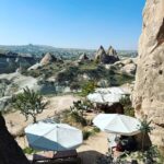 Clare Waight Keller Instagram - After Istanbul the valleys of Cappadocia - what I didn’t do was go in a balloon which is what most people do - what I did do was hike valleys and rocks and discover this incredible place on foot. 1. Gérôme National Park 2. See at the end the most remote cafe I’ve ever been to 3. Fall in the desert 4. Remote refreshments fresh pomegranate juice with a spectacular view 5. @uniqlo :C white shirt with @uniqlo U men’s cargo pants 6/7. Out in the valley 8/9 Room with a view at sunrise 10 The Chimneys #travel #memories #inspiration #turkey #cappadocia #remote #life #restaurant #goals
