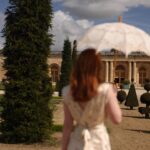 Courtney Halverson Instagram - A little photo diary of our day exploring the gardens of Versailles and the Petit Trianon. • a little doze amongst the flowers • view of the orangeries from @airelleschateaudeversailles • yes I packed this parasol for the occasion • petit Trianon, in which Marie Antoinette had these window coverings installed; they could be raised to shield the entire room and blend in as mirrors, or lowered through the floor to be able to take in the view • petit Trianon staircase • the view of the English garden • petit Trianon • Marie Antoinette and the re-do of her portrait that initially caused scandal by her “too casual” dress. this blue silk gown was the compromise. • our wheels • goodbye, Versailles 🥀 . . . #versailles #petittrianon #gardensofversailles #romanticstyle #feminineenergy