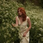 Courtney Halverson Instagram - “I always prefer wildflowers.” “I suspected as much.” 💐 My love of wildflowers and of spring and Jane Austen and romance and Beatrix Potter and The Secret Garden and of antiques and of film scores and far too many other things to name all stems (pun intended) from my mother who raised me with all of the above. Thank you for instilling in me a love of all of this so early on. I am who I am this day because of you. And if you happen to recognize the quote here you very likely are similar, so maybe we grew up loving the same things. 🌿 . . . #romanticstyle #cinematicmoments #wildflowers #ialwayspreferwildflowers #vintagevibes . . Wearing a dress from @rixo paired with beautiful clips from @eponavalley 🌿 lip color is banquette from @iliabeauty