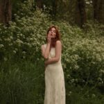 Courtney Halverson Instagram - “I always prefer wildflowers.” “I suspected as much.” 💐 My love of wildflowers and of spring and Jane Austen and romance and Beatrix Potter and The Secret Garden and of antiques and of film scores and far too many other things to name all stems (pun intended) from my mother who raised me with all of the above. Thank you for instilling in me a love of all of this so early on. I am who I am this day because of you. And if you happen to recognize the quote here you very likely are similar, so maybe we grew up loving the same things. 🌿 . . . #romanticstyle #cinematicmoments #wildflowers #ialwayspreferwildflowers #vintagevibes . . Wearing a dress from @rixo paired with beautiful clips from @eponavalley 🌿 lip color is banquette from @iliabeauty
