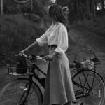 Courtney Halverson Instagram - Evening bike rides have quickly become one of my favorite things about this time of year. A way to enjoy the sunset and see wildflowers (the violets are blooming at the moment) and visit the neighbors - and by neighbors I mean the goslings in the pond down the road and the horses in the field just up the hill. I wore some new and old favorites from my closet and after looking back at this outfit have realized it was probably heavily influenced by Evelyn from The Mummy, and I have to say I don’t mind that. #romanticstyle #cinematicmoments #classicstyle #sezanelovers #bikeriding #softgirlsummer wearing @sezane