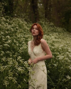 Courtney Halverson Instagram - “I always prefer wildflowers.” 
“I suspected as much.” 💐 

My love of wildflowers and of spring and Jane Austen and romance and Beatrix Potter and The Secret Garden and of antiques and of film scores and far too many other things to name all stems (pun intended) from my mother who raised me with all of the above. Thank you for instilling in me a love of all of this so early on. I am who I am this day because of you. 

And if you happen to recognize the quote here you very likely are similar, so maybe we grew up loving the same things. 🌿
.
.
.
#romanticstyle #cinematicmoments #wildflowers #ialwayspreferwildflowers #vintagevibes 
.
.
Wearing a dress from @rixo paired with beautiful clips from @eponavalley 🌿 lip color is banquette from @iliabeauty