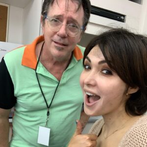 Daniella Pineda Instagram - This is makeup artist John Blake, our department head on “The Plane.” Ok, people come and go in this business, here today gone today TIK TOK influenzers blah blah. POSERS. Then there’s the John’s of the world. As we got to know each other I soon realized that John is a weird little wizard savant who must be protected and preserved in futuristic goo for the sake of cinematic history. Or someone should keep him in a glass case at the Academy of Motion Picture Arts and Science Museum. Here are SOME of John’s credits:

FARGO 
BEETLEJUICE 
NIGHTMARE ON ELM STREET
TROPIC THUNDER
THERE WILL BE BLOOD 
MEN IN BLACK
EVERY FUCKING MARVEL MOVIE EVER. 

We can now all go fuck ourselves. 

Thank you John for touching my face. It was an honor.