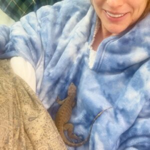 Diane Neal Instagram - Look who’s asleep on my chest!!! #hadnoidea I was a #reptile lady. Actually, a week in and I’m still #notsure. Regardless, she is #adorable This is a #sweet #baby #rhinoceros #iguana Name ideas??? I like #carol 😂 
And yes, I’m wearing a #snuggie It’s #freezing here! #lizard #queen