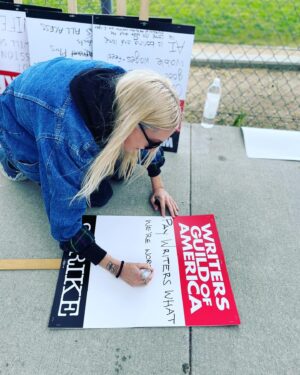 Dylan Meyer Instagram - You may not know this but we (the writers) have struck because The Man is trying to get us down. Without writers, your movies and tv shows will suck. Trust. Our fight for fair wages is so important we’ve been forced to walk around and wave signs about it - and we need your support! If you love stories tell the studios to value the storytellers! #wgastrong writers 4 ever PS doesn’t @kiwilovesyou’s incredible jumpsuit go great w my sign?!?