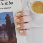 Elísabet Benavent Instagram - Llevo días como el cielo de Madrid: paso del sol más brillante a la nube más espesa. La ansiedad no perdona, te persigue; tiene piernas fuertes y largas, sabe de tus escondites, puede encontrarte en cualquier parte. Necesito de manera urgente una desconexión que solo consigo entre las páginas de un libro, entre unos brazos que me aprieten fuerte o en la más absoluta soledad: aquella que solo se consigue estando rodeada de gente. Me gustan los locales abarrotados en los que todos somos desconocidos. Para enfrentar la ansiedad no me sé ningún truco. Cada vez estoy más segura de que es necesario abrazarla, sin que eso suponga ningún problema en concreto. A veces te abofetea solamente por cansancio y está bien. Solo tengo que dejarla vagar por mis pasillos un tiempo, como si yo fuera una mansión gótica y ella mi fantasma. Después desaparece, porque aunque me encantan las historias de almas en pena, nunca he estado segura de creer en ellas. Aquello en lo que no se cree tiene más peligro de desaparecer. Mi truco es abrazarme. A mí. A mis gatos. A mi necesidad de silencio. A las tardes de tormenta. A los libros. Al capricho de comerse unas gildas en el Café Comercial. A las cosas bonitas y frívolas que no vienen si no a hablar de que merecemos mimos. Como la manicura de limones que me hizo @lirbanails y de la que no querría desprenderme nunca. Me gusta esto de repasar mis días con una galería de fotos sencillas, sin ceremonia, sin el lustre que acostumbramos a ver en estos lares. Feliz martes. ❤️