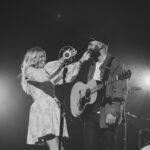 Ellie Holcomb Instagram - JUST now posting about @drewholcombmusic’s two @ryman shows because life in May is crazy (last weekend alone , we had a spring concert at the kids school, two soccer games, 3 dance recitals, 2 Ryman shows, a birthday party!!) , and I chose to just be present the whole weekend and this week with he and my kids , and I have NO regrets about this decision. : ) The shows were absolutely incredible , Drew and his band are just absolute stars @nate_dugger @richiebrins @billamazing @millerkeys , and I am a massive fan of what they do! You can see me and the kids jamming out side stage in a LOT of these videos ! Thankful for our crew as well @sethtalley @s.grantparker @jacthompsonmusic @kevinlillyjr and to our entire team who manages, promotes, and handles all the behind the scenes things that have to happen to tour ! @samantha797 @steelespeakeasy @morganrcombs @chrisfairbank @karrie_tatum_ . So proud of y’all and so thankful for so many friends who came out to support and celebrate with us and for our entire team ! Thx to @donovanwoods , @abrahamalexander , & @josiahandthe for opening/being special guests ! And to @jacthompsonmusic for playing a song each night !!!! Y’all are inspiring ! The beginning of this video is me hauling from deep Franklin from our daughters dance recital to downtown nashville , getting stuck in grid lock traffic , and having to leave our minivan running on Demonbreun street for @morganrcombs to drive to the Ryman while me and the kids RAN to make it time for me to play a few songs at the end of the set on Friday night ! 😅 WILD experience running out of my clothes & into a dress that @samantha797 had ready for me and then onto stage 😂 The profile pic of this reel is me hugging Drew and saying “sorry we got here so late !!” We did the very best we could to get there on time , and the team made it all work !! Takes a village, y’all, and I am thankful for ours !!! Meanwhile , glad to have my guy home & to celebrate on Sat night 500 million streams of his music !!! Wooo!!! Also, thx to @kt.sura and @ashtinpaige for taking pics of these two epic nights !