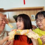 Emily Chan Instagram - 托冰淇淋的福，我们多了一张全家福 💖 爸媽比我更愛吃甜品，家裡的冰淇淋大多都是他们吃掉的， 我怎么抢都抢不赢 🤣 看著他们開心地吃冰，會有一種說不出口的安心。 新年到了， 一支 Wall’s Honey Butter Almond 換家人的笑容。 绵密的蜂蜜牛油冰淇淋，咸甜味均衡， 裹上脆口杏仁颗粒及浓郁白麦脆皮 口味清新淡雅 只要爸妈一笑， 家就亮起來了。 @wallsmalaysia #TripleTheBliss #WallsHoneyButterAlmond