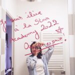 Enola Cosnier Instagram - Cette première photo c’est le début de tout ! J’ai écrit « Je suis élève à la Star Academy 2022 » le 28 juin 2022 ,en rentrant de mon audition à l’Atrium de TF1. Je faisais alors parti des 120 derniers candidats sélectionnés. Ce jour-là, je rencontrais pour la première fois Louis, sans me douter une seule seconde de la place qu’il prendrait dans mon cœur. J’ai passé l’été le plus long de ma vie, à attendre une réponse qui n’arrivait pas. Puis, arriva ce jour du 16 septembre 2022. C’est ce jour-là, en rentrant du plateau de « Danse avec les Stars », que j’écris sur mon miroir « Oui, tu es prise !», parce que j’étais la première candidate de la Star Academy 2022, annoncée en Prime Time par @nikosaliagas Je me souviens de la première fois où j’ai rencontré @luciebernardoni . Je devais faire ma prise de tonalité pour la chanson « Voilà » avec ma nouvelle répétitrice. Et j’ai vécu mon moment « Fan Girl » le plus intériorisé de ma vie quand sa caméra s’est ouverte ,et que je l’ai reconnu sans trop y croire : « Bonjour, moi c’est Lucie ! - OUI JE SAIS ! Je vous ai reconnu ! » Je ne savais pas que cette femme ( et ma @marleneschaff adorée ) deviendrait une de mes lumières réconfortantes de cette aventure, deviendrait Maman Lulu ou Mama Lucia ( quand c’est Lucie qui le dit haha). Tellement de moments, hors des caméras, qui n’appartiennent qu’à nous. Un peu comme ces photos à l’argentique, que j’ai adoré vous partager. J’ai été très ému quand j’ai découvert les premiers tirages…on était ✨beaux ensemble ✨ Merci à la production d’avoir accepté que je prenne ce petit objet avec moi au sein du château. Merci à mes camarades, et professeurs d’avoir été les meilleurs modèles photo ever 🙌🏼 Ce soir, vous pourrez nous retrouver sur TF1, à partir de 21h10 pour « Les 12 Coups de Noël ». Je vous souhaite de passer un beau réveillon , et un merveilleux Noël 🎄🎁 Je vous embrasse, Enola ⭐️ @albilouis @anishajo.music @leaa.hdd @ahcene.off @carladonaoff @chriscamalon @tianaa.off @amisse.music @canaby.jr @cenzo_thn @sr_stanislas @paola.prrn @laure.balon.coaching @pierredebrauer @yanismarshall @adelinetoniutti @michael.mmcgold
