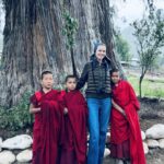 Eva Herzigová Instagram - Couldn’t resist this moment…there they were just standing in those striking deep red coloured robes that caught my eye first. Then I realised the majesty of the giant cypress tree they were playing in front of. It’s the oldest and perhaps the biggest tree in Bhutan.