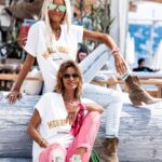 Ingrid Chauvin Instagram - Le T-SHIRT MESDEMOISELLES ici décliné en blanc... un t-shirt lumineux, avec un grand col V qui fera ressortir votre bronzage. Un joli imprimé à paillettes doré. On vous propose ici 2 combos différents, Nathalie avec le JEANS BRAXTON BLEACH et des boots pour un look bohème. Ingrid avec le PANTALON MARA ROSE et les SNEAKERS ZAGO pour la touche de couleur. Un t-shirt à la dégaine oversize, qui se porte avec tous vos looks du quotidien... ❥T-SHIRT MEDEMOISELLES BLANC ❥PANTALON MARA ROSE ❥SNEAKERS ZAGO BLANC/VERT ❥ BANDANA PINK ❥ BOOTS MASHA BEIGE ❥ JEANS CG BRAXTON BLEACH ❥❥❥❥❥❥❥❥ The MESDEMOISELLES T-SHIRT here in white... a bright t-shirt with a large V-neck that will bring out your tan. A pretty golden glitter print. Here we propose 2 different combos, Nathalie with the BRAXTON BLEACH JEANS and boots for a bohemian look. Ingrid with MARA PANTALON ROSE and ZAGO SNEAKERS for a touch of colour. An oversized t-shirt that can be worn with all your everyday looks... ❥T-SHIRT MEDEMOISELLES BLANC ❥PANTALON MARA ROSE ❥SNEAKERS ZAGO BLANC/VERT ❥ BANDANA PINK ❥ BOOTS MASHA BEIGE ❥ JEANS CG BRAXTON BLEACH #ingridchauvinxgrungemama #ingridchauvin #grungemama #summerlook #look