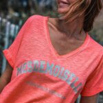 Ingrid Chauvin Instagram - Le corail fluo est la couleur qui revient en force tous les étés … il est associé ici avec un peint argenté à paillettes . Le T-SHIRT MADEMOISELLE CORAIL FLUO est le t-shirt à porter tout l été . Je le porte en version look de plage avec le SHORT OZZY BLEU , un short effiloché très bohème, Nathalie en version plus habillée avec le JEANS BRAXTON BLEACH. On peaufine le look avec les SNEAKERS RICO pour un total look pailletés & rose . J adore ! Et vous vous aimez ??? Je vous embrasse 💗. @grunge_mama @philippewarrin #partenariat