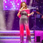Jane McDonald Instagram – I loved this disco inspired jumpsuit! I bought in New York, it had a tequila sunrise vibe – and you know how I love a cocktail! I added a cape to cover my arms (which I’m conscious of). I absolutely loved performing in it!! 
(Photos from my 2019 Christmas show at @firstdirectarena in #leeds )