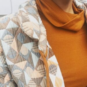 Jasika Nicole Instagram - I didn’t hop onto the quilted jacket trend til @byhandlondon released the #NerrisaCoat pattern a couple months ago. I loved the collar, the oversized fit and the long length, three elements that I had not previously seen in quilted coat patterns, and I had the *perfect* fabric for it- a geometric reversible quilted cotton smack in the middle of my color palette from @corefabrics. The pattern is very simple, pretty beginner friendly, and requires very little fit adjusting because it’s so oversized. I made the smallest size available (it goes up to a size E/ 61.75” bust) but it’s still incredibly roomy, like I could probably fit a sweater AND another coat under this lol. If I were to make it again I would probably slim down the fit by a couple inches and shorten it to shin length, which I might still do, but I wanted to get some wear out of this length before I chopped it up. I opted not to add buttons to the front and just have this be a kind of open jacket for layering. I made the bias binding myself and this is the only issue I had with the pattern- it says you need 5 meters of binding but I easily used 3 times that much for this view (I stopped counting after the third time I had to pull out my tools to make more tape 😵‍💫), so maybe that amount was meant for the shorter version of the jacket (because it doesn’t give different amounts for the different views). Thankfully I had just enough tencel scrap fabric to make all the tape I needed. The bias binding gives the jacket a nice pop of color while still feeling a bit neutral and I love how the colors in the fabric and tape play off of each other. I’m on the fence about the patch pockets on my version and think it would look even better with inset pockets, and because of the bulk of the quilted fabric, the drop sleeves look a little funky at the seams(I prefer inset sleeves). But those design choices are what makes this such a simple and quick pattern to finish, and I’m still happy with how this came out. The fabric is structured but soft and wearing it feels like you’re draped in a blanket cocoon- it actually makes a pretty great housecoat if you’re careful to not trip over it 😂