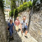 Jennifer Holland Instagram - We went to #lakecomo with some friends and I have so many photos I want to share, but I’ll open with this one because we all look cute with our shoulder bags and sensible shoes. And, also, it’s @theyearofelan ‘s sober birthday today. He’s old as fuck. 🎉