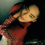 Jody Watley Instagram - #tbt 💋 1988 in Burgundy studded sleeves Jean Paul-Gaultier Bolero & jeans - I’m not sure who the photographer was /is 😞 #jodywatley #jeanpaulgaultier #jpg #brows #redlipstick💄 #wingedliner #jodywatleystyle