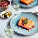 Judy Joo Instagram – Delighted my Green Chilli Glazed Salmon recipe has been featured in @cityamtravel! This dish is packed with a wonderful blend of spicy, sweet, and umami flavours. Here’s a brief run-down for you to have a go at home:

1️⃣ Glaze: Gently fry finely chopped garlic and jalapeños in vegetable oil until softened. Mix together soy sauce, brown sugar, and rice wine vinegar. Add to the pan, stir well, and simmer until reduced by half. Finish with a drizzle of sesame oil.

2️⃣ Spring Onion Salad: For the dressing, combine soy sauce, rice wine vinegar, gochugaru (Korean chilli flakes), roasted sesame oil, sesame seeds, and sugar. Cut spring onions into thin strips and immerse in ice-cold water until they crisp up. Toss in the dressing.

3️⃣ Salmon: Heat oil in a pan and fry the salmon fillets until golden brown and cooked to your preference. Arrange salmon on plates, spoon over the glaze, and garnish with the Spring Onion Salad and green chilli slices. Add a pinch of silgochu for an extra kick.

Serve with yuja pickles and a side of cooked rice. Enjoy your meal! 🍴

What recipe would you like to see next? Let me know in the comments! And don’t forget to visit my website for more delicious recipes.

For the full recipe and article, head over to #CityAM. Don’t forget to share your culinary creations with us using #GreenChilliGlazedSalmon. Happy cooking! 🍳
•
•
•
•
•
#koreanfood #salmon #chef #cheflife #chefsofinstagram #cook #cooking #chefs #fish #truecooks #ChefLife #Foodie #FoodPorn #InstaFood #Foodstagram #ChefsofInstagram #FoodPhotography #FoodGasm #FoodLover #FoodBlog #FoodPassion #FoodArt #FoodInspiration #FoodieLife #Cooking #Gourmet #FoodCulture #FoodieGram