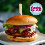 Judy Joo Instagram – Happy Sunday! 🙌 Perfect time to share a recipe highlight from my @SundayBrunchc4 appearance, where I made my famous Korean Fried Chicken Sandwich– just like the one we sell @seoulbirduk. This is not just a sandwich, it’s an experience. Extra crispy on the outside, and deliciously juicy on the inside. Let me walk you through it. 🍗🇰🇷 

For the chicken precoat:
30g cornflour/starch
2½ tsp sea salt
½ tsp baking powder
Freshly ground black pepper
6 chicken boneless skinless thighs or breasts
Mix together salt, cornflour, baking powder, and  pepper. Toss the chicken pieces in the mixture to cover, shaking off any excess. Place chicken on a wire rack to keep dry. 

For the Batter:
64g cornflour/starch
20g fine matzo meal
30g plain flour
2 tbsp Korean chilli flakes (gochugaru)
1 tbsp sea salt
2½ tsp garlic powder
2½ tsp onion powder
¼ tsp baking powder
90ml vodka
Mix together all of the above ingredients and add just enough cold water to make the consistency like paint, like a thickish slurry.

For the BBQ sauce:
3 tbsp Korean chilli paste (gochujang)
3 tbsp ketchup
2 tbsp dark brown sugar
2 tbsp dark brown soy sauce
1 tbsp toasted sesame oil
2 tsp grated peeled fresh ginger
2 garlic cloves, grated or finely chopped
Mix all of the above together in a small sauce pan, bring to a simmer over low heat, allow to cook over low heat for about 3 mins while whisking (do not let burn). Remove from heat, set aside. 

For the Sandwich:
6 potato buns, split, buttered, and toasted (or pan fried, flat side down)
6 tbsp kewpie mayonnaise
½ head iceberg lettuce
6 slices red onion or tomato
250g cabbage kimchi, diced

Dip the precoated chicken into the wet batter and immediately fry in oil at 350F / 180C. If you want to double fry (extra crispy) do the first fry at 300F/150C, allow chicken to rest then do the second fry at 350F/180C until  bronzed. Spread bun with mayo, place chicken in, slather with bbq sauce, top with lettuce, onion, kimchi, top bun and enjoy. 

What recipe would you like to see next? Let me know in the comments! And don’t forget to visit my website for more delicious recipes. #KoreanFriedChicken #SundayBrunch