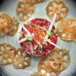 Judy Joo Instagram - Do you like steak tartare? Have you tried Korean Steak Tartare, known as Yukhwe? 🇰🇷🥩 Distinct from its Western counterpart, this Korean delicacy melds raw beef with the aromatic hint of sesame oil, the nuttiness of pine nuts, and the refreshing undertones of Asian pear, crafting a symphony of flavors and textures. For a genuine touch, go for the best quality and freshest fillet steak, and let the toasted sesame oil work its magic, infusing an authentic Korean aroma and taste. The julienned Asian pear adds a dash of sweetness and freshness, while toasted pine nuts lend a delicate earthy bite. The thinly sliced spring onions offer a pop of color and taste. If you plan to serve it later, keep lemon wedges on the side to ensure the beef’s vibrant color remains untouched, as the acidity will slightly “cook” the meat. For an exquisite finale, pair with lotus root chips as a delightful crispy croute. For the full culinary journey, visit the link in my bio or explore Judyjoo.com 🙌 • • • • #chef #cheflife #koreanfood #steaktartare #yukhwe #foodie #koreanfusion #foodpassion #asianpear #pinenuts #rawbeef #foodculture #authentickorean #foodpresentation #gourmet #instafood #koreantradition #JudyJoo #korea #korean #koreanfoodmadesimple #judyjoo #beef #meat #tartare