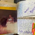 Karine Teles Instagram – Durante alguns anos, na minha adolescência, eu tive agenda-diário. Anotava compromissos -que eram poucos- aniversários, datas especiais, mas principalmente registrava já com um desejo literário, os acontecidos dos dias de alegrias e angústias. Guardava as cartas que recebia (sim, mandávamos cartas) fotos impressas, ingressos do cinema, embalagem de guloseimas exóticas, pulseirinha do Bonfim que algum parente trouxe da Bahia (será que se eu colocar alvora ela ainda vai me trazer meu desejo?). Tenho 3 dessas agendas, mas essa é a mais gorda. 1992 ano em que completei 14 anos. Mais ou menos a mesma idade que meus filhos tem agora. Outro dia sentamos juntos e lemos vários trechos. Foi emocionantemente hilário. Eu, dramática e romântica (ainda sou, fazer o quê) registrando acontecimentos banais aos quais atribuía grande significado. Teorizando sobre um passeio no calçadão ou destrinchando o sentimento depois de um primeiro namoro que durou exatos 104 dias (fiz as contas e anotei). “Mãe, que engraçado, você ficou toda nervosa porque viu o menino de longe? Só porque viu?” Ele riam aliviados de encontrar na figura leme, um tando de desordem e semelhança. Fiquei feliz demais com essa noite. Nesta página eu estou segurando meu primo @pedrodrinpe no colo. Lembro de me sentir adulta e desejar muito um dia ser mãe (desejei isso desde que me entendo por gente). Casa da minha avó Maria, em Petrópolis. Era Outono e eu adorava essa roupa que inclusive seguiria usando hoje em dia! A folha dobrada e presa com clips era algum segredo extra que me parecia melhor protegido assim. Ah! Guardei tb o papel de um bombom qualquer. “Water Proof Original Colors of the Earth” #tbt #adolescentes #anos90