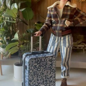 Kate Micucci Instagram - I almost took the wrong navy blue suitcase home from the airport. Went home and drew on it to make sure I wouldn’t do that again. Did my best to be like a Price is Right model to show the product.