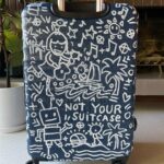 Kate Micucci Instagram - I almost took the wrong navy blue suitcase home from the airport. Went home and drew on it to make sure I wouldn’t do that again. Did my best to be like a Price is Right model to show the product.