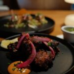 Kathryn Dunn Instagram - a date night at @windmillsbrewery 🥰🍻🫶📚 what I ate👇 🍹 The Haka - a Tiki cocktail with citrussy bright tequila, subtle notes of vanilla and hints of butterscotch, cola, and dried fig (Alex had the “Smoking Barrel” 💨🥃) 🥘 Fennel & Cumin Crusted Scallops - PERFECTLY COOKED queen scallops with fennel & cumin crust habanero buttermilk sauce 🍗 Hot ‘n Sweet Guava Chicken - sweet and spicy guava-marinated tandoori chicken 🍤 Seafood Moilee - Rainbow trout, shrimp, casava podimas, I WANT TO BATHE IN THE MOILEE SAUCE it was so good 🤤 #grandscapetx #dallasrestaurants #dallasfood #thecolony