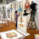 Kristy Cha Ray Chu Instagram - 睽違多年，終於要在台北舉辦個展，地點選在我任教的實踐大學，這裡對我的意義非凡，除了是我看過眾多藝術空間裡，最大器的展廳，我對它還有一份說不出的情感。 當年從紐約回來找到的第一份（也是唯一的）工作，之後就一直待在這裡，二十多年來實踐給了我一個超級棒的教學環境，與一群獨特有天份的學生，雖然自己並非這裡畢業，卻在我生命中佔了很重要的位置。 有了在實踐辦展的想法，便著手規劃，從展覽主題、展出形式、規劃場地 、選作品都不假他人之手（自己最瞭解自己)，在展廳搭建了三座高340cm，總長3200cm的牆。 從我的作品集精選出三十幾幅，近3年最具代表性的自畫像、人物、玩具畫作，包含兩幅從未公開的2021年最新人像畫（母親、小P)，希望每一位參觀者走進來，立即被眼前的繽紛色彩環繞，置身於我的藝術之中。 前天一早9點佈展團隊開始作業，首先到我工作室做最後確認（每一幅畫都覆蓋無酸紙＋泡泡紙包覆），接著上貨車、運送到展廳，再依照設計圖把畫平放在每個區域的地上。 正準備開始掛畫，竟然發現我漏掉一幅作品，原本想說算了，反正也沒有人知道（但我知道啊），於是緊急拜託好友，請朋友的朋友臨時調度一輛貨車，殺到我的工作室找出那幅畫，運回展廳（昏倒）。 這次光是空間的設計圖，考量到場地限制以及觀展動線，就改了好多版本，至於要展出哪幾幅畫，也是選了又換再換，擔心數量不夠（怕你們看不過癮），又要衡量整體觀看的品質。 更別說展廳不允許在牆上釘任何釘子，而新打造的牆面尺度很大，要能夠承受十幾幅裱框的大型畫作（很重），上下兩層懸掛，在支撐結構上，對於木工師傅是極大的挑戰。 當然掛畫團隊的付出更讓我佩服，專業有耐心之外，遇到難題立馬解決，好幾次快接近完工，而我覺得還可以突破（我常這樣要求我學生，他們都快瘋了），提出了意見，團隊都全力配合。 晚上十點，原以為大功告成，我又提議要不要嘗試另一種照明方式，他們二話不說就試，效果出奇的好，工作人員爬上爬下200公分的梯子，為每一幅畫重新安裝新的聚光燈，原本預計９小時的佈展工程，最終15小時完成。 就算之前我有過比這大好幾倍的展覽經驗，感覺還是跟第一次展出一樣，壓力不減反增，我還是一樣沒把握 、一樣很緊張，擔心作品不夠好、撐不起這個展，反正就是會想很多很多。 前一晚還硬是把一幅畫拿出來重畫（我是不是瘋了），整天都無法排便，中間一度躲在學校廁所裡掉眼淚，直到所有的畫都上了牆，我站在展廳中央，心裡的石頭才慢慢放下。 記得爸爸還在的時候，總是拒絕來我的工作室，他對於我沒有任何保留，直視內心最深處，一筆一筆像是自我解剖所刻下的那些自畫像，一點都不欣賞，也不想欣賞，他總是帶點惱怒的說我把自己畫成這樣，什麼人敢來娶我？ 當時的我年輕氣盛，心高氣傲的強調，我的創作從來就沒想過要取悅任何人，父女倆每次談到這個話題，總是不歡而散。 2012年爸爸因病去世，我才意識到自己的創作動力，有很大一部分就是為了證明給他看，表面上或許我很不屑，但心裡期盼著他的一句肯定，而爸爸的離開，讓我強烈感受到人生無法回頭，他再也看不到我的畫，看不到我還在創作這條路上奔馳。 前陣子，無意間在書房抽屜裡，翻到一疊小時候的隨手塗鴉，媽媽才想起那是爸爸留著的，這麼多年一直擺在那裡，我想爸爸當時一定看見了這個女兒的不同，雖然從未說出口，但用著他的方式默默地鼓勵與愛我。 無論你是誰、幾歲，透過這個展，來到我的世界，你會從我的畫裡看見自己，喚醒內心深處，那個和我一樣渴望被認同、被愛的孩子。 #送給自己與粉絲的禮物 展覽：破框而出 - 在繪畫創作中，找回初學者的眼光與勇氣 地點：實踐大學 敏初聽/台北市中山區大直街70號(捷運文湖線 大直站) 展期：2021/5/3-5/15 時間：11:00am-6:00pm週一至週日(免費入場) 感謝成就這個展的幕後團隊： 運輸佈展/達奇藝術 展場施工/璟程設計 空間設計/昱安 展品規劃/克旻 人員配置/彥韋 全程監督/竑嘉 #一步一步朝著夢想前進