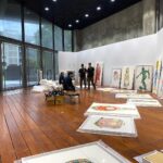 Kristy Cha Ray Chu Instagram - 睽違多年，終於要在台北舉辦個展，地點選在我任教的實踐大學，這裡對我的意義非凡，除了是我看過眾多藝術空間裡，最大器的展廳，我對它還有一份說不出的情感。 當年從紐約回來找到的第一份（也是唯一的）工作，之後就一直待在這裡，二十多年來實踐給了我一個超級棒的教學環境，與一群獨特有天份的學生，雖然自己並非這裡畢業，卻在我生命中佔了很重要的位置。 有了在實踐辦展的想法，便著手規劃，從展覽主題、展出形式、規劃場地 、選作品都不假他人之手（自己最瞭解自己)，在展廳搭建了三座高340cm，總長3200cm的牆。 從我的作品集精選出三十幾幅，近3年最具代表性的自畫像、人物、玩具畫作，包含兩幅從未公開的2021年最新人像畫（母親、小P)，希望每一位參觀者走進來，立即被眼前的繽紛色彩環繞，置身於我的藝術之中。 前天一早9點佈展團隊開始作業，首先到我工作室做最後確認（每一幅畫都覆蓋無酸紙＋泡泡紙包覆），接著上貨車、運送到展廳，再依照設計圖把畫平放在每個區域的地上。 正準備開始掛畫，竟然發現我漏掉一幅作品，原本想說算了，反正也沒有人知道（但我知道啊），於是緊急拜託好友，請朋友的朋友臨時調度一輛貨車，殺到我的工作室找出那幅畫，運回展廳（昏倒）。 這次光是空間的設計圖，考量到場地限制以及觀展動線，就改了好多版本，至於要展出哪幾幅畫，也是選了又換再換，擔心數量不夠（怕你們看不過癮），又要衡量整體觀看的品質。 更別說展廳不允許在牆上釘任何釘子，而新打造的牆面尺度很大，要能夠承受十幾幅裱框的大型畫作（很重），上下兩層懸掛，在支撐結構上，對於木工師傅是極大的挑戰。 當然掛畫團隊的付出更讓我佩服，專業有耐心之外，遇到難題立馬解決，好幾次快接近完工，而我覺得還可以突破（我常這樣要求我學生，他們都快瘋了），提出了意見，團隊都全力配合。 晚上十點，原以為大功告成，我又提議要不要嘗試另一種照明方式，他們二話不說就試，效果出奇的好，工作人員爬上爬下200公分的梯子，為每一幅畫重新安裝新的聚光燈，原本預計９小時的佈展工程，最終15小時完成。 就算之前我有過比這大好幾倍的展覽經驗，感覺還是跟第一次展出一樣，壓力不減反增，我還是一樣沒把握 、一樣很緊張，擔心作品不夠好、撐不起這個展，反正就是會想很多很多。 前一晚還硬是把一幅畫拿出來重畫（我是不是瘋了），整天都無法排便，中間一度躲在學校廁所裡掉眼淚，直到所有的畫都上了牆，我站在展廳中央，心裡的石頭才慢慢放下。 記得爸爸還在的時候，總是拒絕來我的工作室，他對於我沒有任何保留，直視內心最深處，一筆一筆像是自我解剖所刻下的那些自畫像，一點都不欣賞，也不想欣賞，他總是帶點惱怒的說我把自己畫成這樣，什麼人敢來娶我？ 當時的我年輕氣盛，心高氣傲的強調，我的創作從來就沒想過要取悅任何人，父女倆每次談到這個話題，總是不歡而散。 2012年爸爸因病去世，我才意識到自己的創作動力，有很大一部分就是為了證明給他看，表面上或許我很不屑，但心裡期盼著他的一句肯定，而爸爸的離開，讓我強烈感受到人生無法回頭，他再也看不到我的畫，看不到我還在創作這條路上奔馳。 前陣子，無意間在書房抽屜裡，翻到一疊小時候的隨手塗鴉，媽媽才想起那是爸爸留著的，這麼多年一直擺在那裡，我想爸爸當時一定看見了這個女兒的不同，雖然從未說出口，但用著他的方式默默地鼓勵與愛我。 無論你是誰、幾歲，透過這個展，來到我的世界，你會從我的畫裡看見自己，喚醒內心深處，那個和我一樣渴望被認同、被愛的孩子。 #送給自己與粉絲的禮物 展覽：破框而出 - 在繪畫創作中，找回初學者的眼光與勇氣 地點：實踐大學 敏初聽/台北市中山區大直街70號(捷運文湖線 大直站) 展期：2021/5/3-5/15 時間：11:00am-6:00pm週一至週日(免費入場) 感謝成就這個展的幕後團隊： 運輸佈展/達奇藝術 展場施工/璟程設計 空間設計/昱安 展品規劃/克旻 人員配置/彥韋 全程監督/竑嘉 #一步一步朝著夢想前進