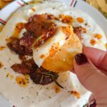 Laura Vitale Instagram – Y’all have you whipped up some brie and topped it with unbelievably crispy sweet sticky rosemary infused bacon and drizzled with chili oil and kissed by a touch of honey?!!! No?!!! WHAT ARE YOU WATING FORRRRR?! Seriously though, it’s sublime and so easy!! Whip up some brie in a high powered food processor with a couple tbsp of milk (don’t use this little one like I did because I needed to switch to my big powerful one) and whiz it up until it’s creamy, smooth and decadent. Set it in the fridge for a few min while you bake the bacon. Add chopped bacon to a little oven safe dish, add about a tbsp or two of maple syrup (I used about 6oz of bacon for this batch) a good sprinkle of bbq seasoning (I buy mine) or any seasoning you like along with a little fresh rosemary and bake at 375 about 15ish min or until crispy. Plate the Brie in a shallow bowl, top with the crispy bacon then drizzle some chili oil (I used TJ brand) and a little drizzle of honey and served it with crackers. MY LAWDDDSDDDD ITS SENSATIONAL!!! Must make!!