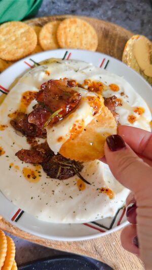 Laura Vitale Instagram - Y’all have you whipped up some brie and topped it with unbelievably crispy sweet sticky rosemary infused bacon and drizzled with chili oil and kissed by a touch of honey?!!! No?!!! WHAT ARE YOU WATING FORRRRR?! Seriously though, it’s sublime and so easy!! Whip up some brie in a high powered food processor with a couple tbsp of milk (don’t use this little one like I did because I needed to switch to my big powerful one) and whiz it up until it’s creamy, smooth and decadent. Set it in the fridge for a few min while you bake the bacon. Add chopped bacon to a little oven safe dish, add about a tbsp or two of maple syrup (I used about 6oz of bacon for this batch) a good sprinkle of bbq seasoning (I buy mine) or any seasoning you like along with a little fresh rosemary and bake at 375 about 15ish min or until crispy. Plate the Brie in a shallow bowl, top with the crispy bacon then drizzle some chili oil (I used TJ brand) and a little drizzle of honey and served it with crackers. MY LAWDDDSDDDD ITS SENSATIONAL!!! Must make!!