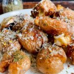 Laura Vitale Instagram – These one pan crispy potatoes were the potato winner of 2022 and I simply couldn’t resist sharing them again because they are so unbelievably good and easy!! Add baby potatoes in a deep skillet and cover with water (about half an inch above the potatoes) add a generous glug of olive oil, about 1/4 cup, and a hefty pinch of salt, then bring to a boil, once the water is reduced by half, add cloves of garlic fresh herbs and give them a gentle squeeze then let the magic of cooking do what it does, the water will evaporate and the oil will crisp them up to perfection, make sure you flip them around to get evenly crisp. Serve with an extra grating of parm and indulge 😘