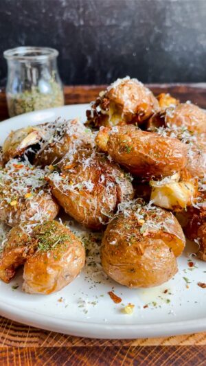 Laura Vitale Instagram - These one pan crispy potatoes were the potato winner of 2022 and I simply couldn’t resist sharing them again because they are so unbelievably good and easy!! Add baby potatoes in a deep skillet and cover with water (about half an inch above the potatoes) add a generous glug of olive oil, about 1/4 cup, and a hefty pinch of salt, then bring to a boil, once the water is reduced by half, add cloves of garlic fresh herbs and give them a gentle squeeze then let the magic of cooking do what it does, the water will evaporate and the oil will crisp them up to perfection, make sure you flip them around to get evenly crisp. Serve with an extra grating of parm and indulge 😘
